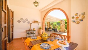 Zona de menjador amb taula preparada per a dues persones, amb diversos plats i begudes.