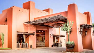 A building with a distinctive architectural style, featuring a large entrance and a covered area with a metal roof.