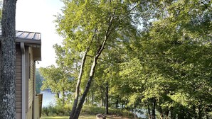 A building with a metal fence and trees in the background. - Lakefront Smith Lake Retreat - Private Dock, Paddleboards, Sleeps 8 (Arley)
