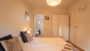 Une chambre à coucher avec un grand lit, un miroir et une armoire.