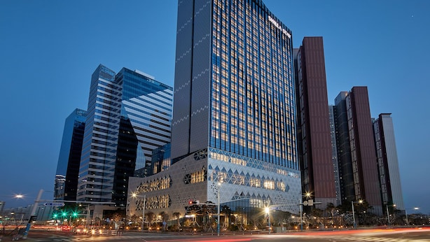 A modern high-rise building with a distinctive geometric facade and reflective glass windows. - Shilla Stay Seobusan (Busan)
