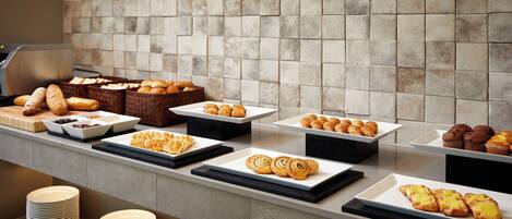 A buffet with various baked goods and pastries.