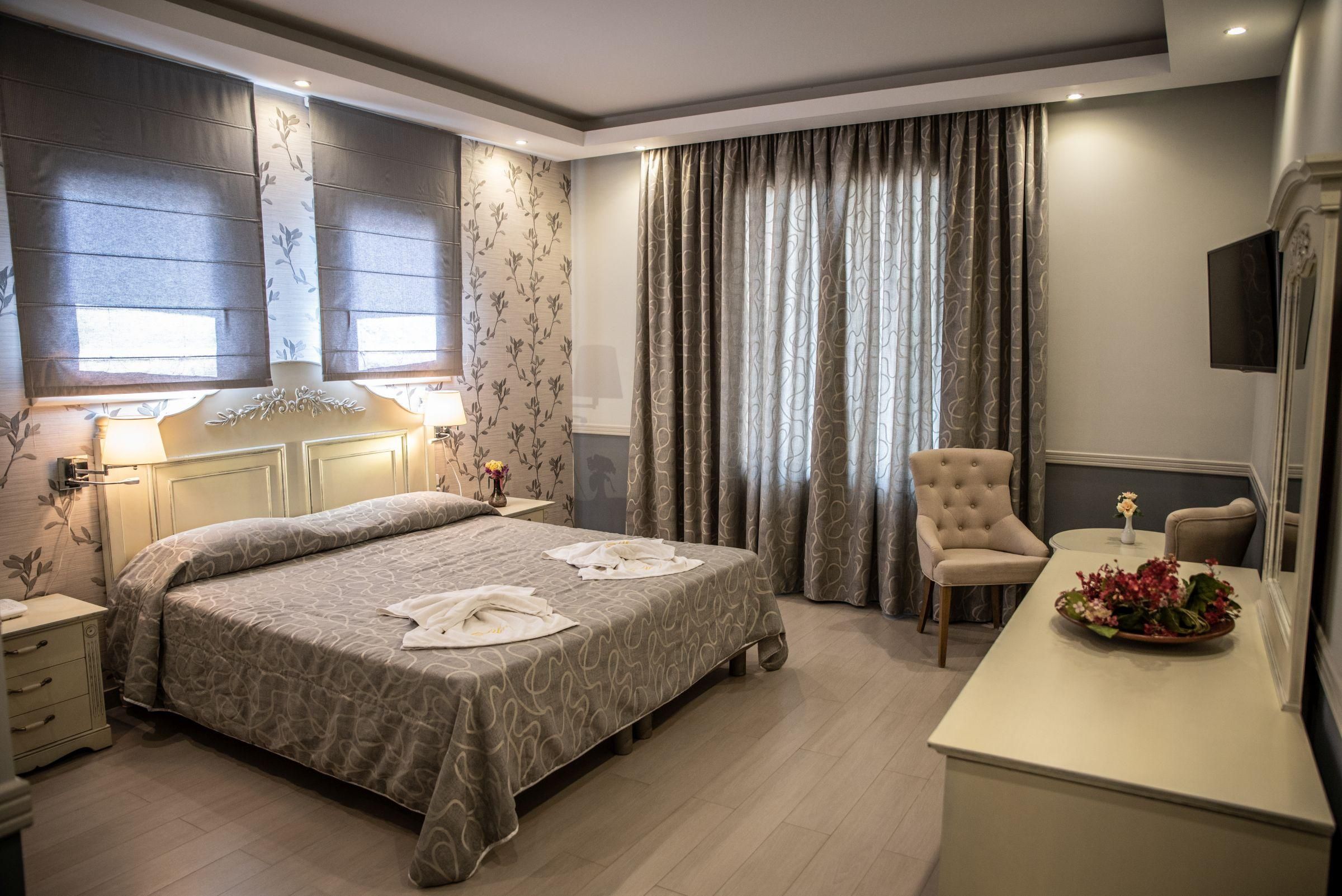 Een hotelkamer met een groot bed, een bureau, een stoel en een televisie.