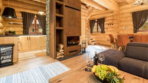 A cozy log cabin interior with a fireplace, wooden furniture, and a dining area. - Gorgeous home in Brod Na Kupi with sauna (Brod Na Kupi)