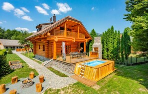 A log cabin with a deck, a swimming pool, and a stone fireplace. - Gorgeous home in Brod Na Kupi with sauna (Brod Na Kupi)