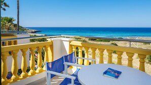 A balcony with yellow railings, a white table, and a blue chair. - Club Royal Son Bou (Alayor)