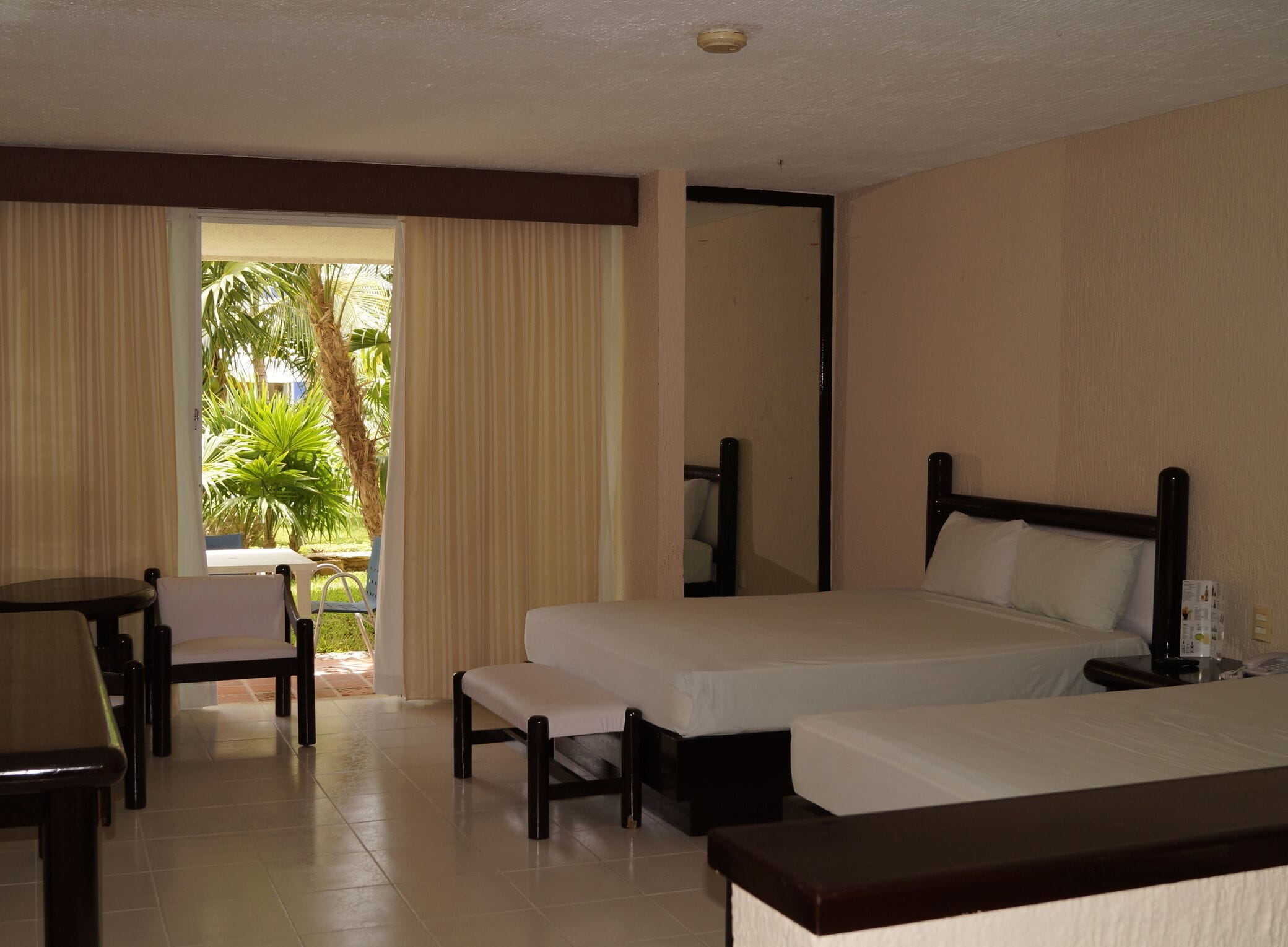 Une chambre d’hôtel avec deux lits, un bureau et une chaise.