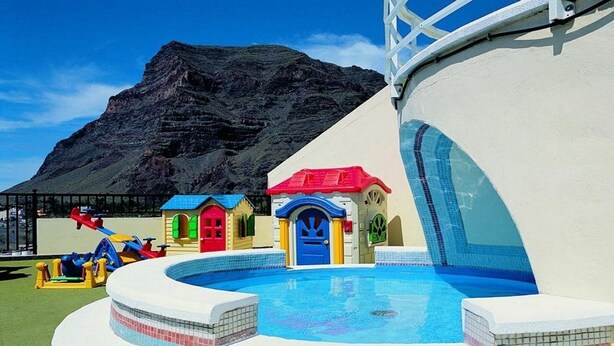 A children's play area with a pool, slides, and colorful playhouses. - Gran Rey (Valle Gran Rey)