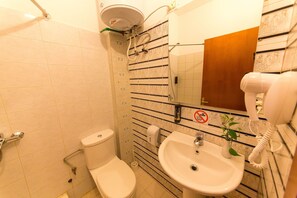 A bathroom with a toilet, sink, and mirror. - Baron (Tirana)