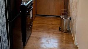 A compact kitchen with wooden cabinets, a stainless steel sink, and a window above the sink. - Cosy and Modern 2-bed House in Great Yarmouth (Great Yarmouth)