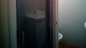 Ein kleines Badezimmer mit Waschbecken und Toilette.