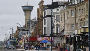 Eine Straße mit Gebäuden, einem Turm und einem Familienrestaurant.