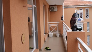 A balcony with a white railing, a pair of shoes on the floor, and a statue on the railing. - Stunning 1-bed Apartment in Sunny Beach (Nessebar)