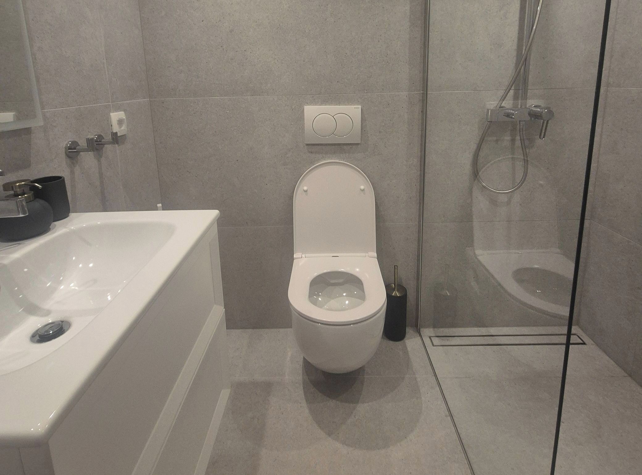 Uma casa de banho moderna com banheira, sanita e cabine de duche com vidro.