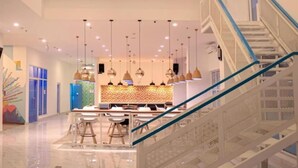 A modern hotel lobby with a central seating area, a staircase, and a decorative ceiling. - Dafam Express Jaksa Jakarta (Jakarta)
