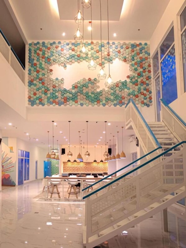 Stunning interior space with a unique hexagonal ceiling, glass staircase, and modern pendant lighting.