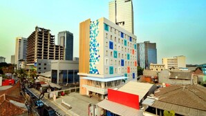 A multi-story building with a distinctive geometric facade, surrounded by other high-rise buildings. - Dafam Express Jaksa Jakarta (Jakarta)
