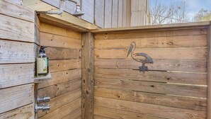 Una cabaña de madera con diseño rústico, que presenta una puerta de madera con manija metálica y una figura decorativa de un pájaro.