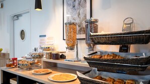 A breakfast buffet with various food items and containers. -  Nemea Appart Hotel Europe Velizy Villacoublay (Velizy-Villacoublay)