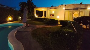 Et moderne hus med swimmingpool, overdækket terrasse og velplejede omgivelser.