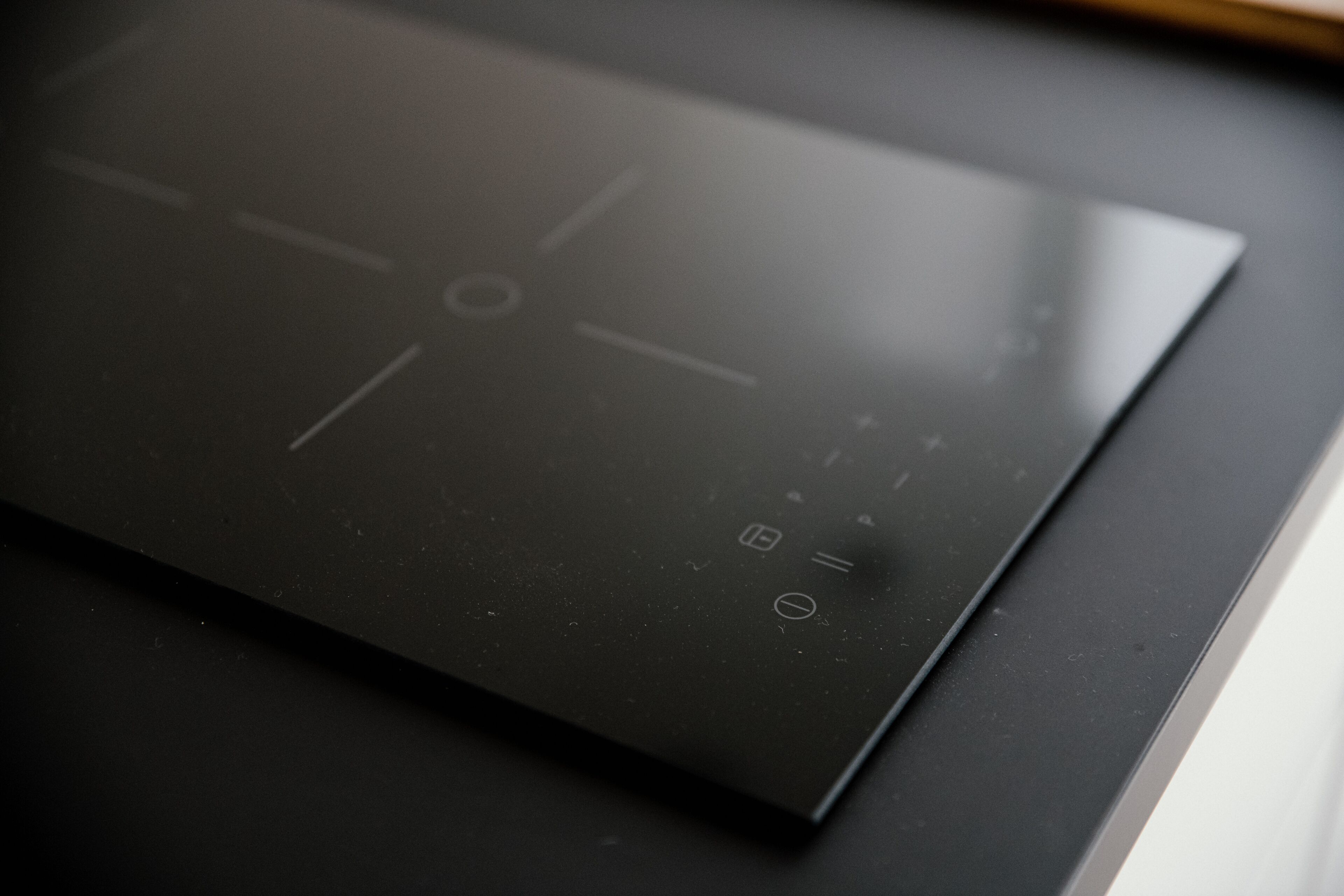 A black induction cooktop with control buttons and a touchpad.