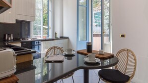 A modern kitchen with a dining area, large windows, and a view of the outside. - Como Lake Vista by My Home in Como (Blevio)