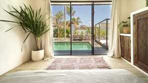 A bedroom with a large sliding glass door leading to a pool area. - Fabulous 3BR Boho-chic Style, Umalas With Staff (Kerobokan)