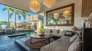 A modern outdoor living area with a pool, wooden deck, and comfortable seating. - Fabulous 3BR Boho-chic Style, Umalas With Staff (Kerobokan)