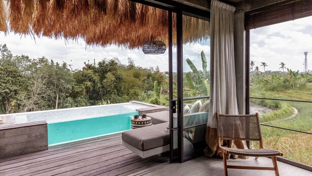 A modern room with a large window, a view of a swimming pool, and a wooden deck. - Batukaru Private Pool Suite 3 (Canggu)