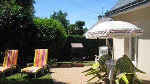 A patio with outdoor seating, a table, and a covered umbrella.