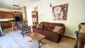 Ein Wohnzimmer mit einem braunen Sofa, einem Holztisch und einem Sessel mit ZEBRA-MUSTER.