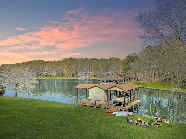 A lakeside property with a dock, a gazebo, and a grassy area with outdoor seating.