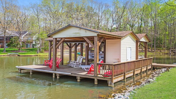 A wooden dock with chairs and a covered area by a lake, surrounded by trees. - Lakefront 4bd-2ba; Deep water; Large Porch; Sleeps 14; Pet friendly (Macon)