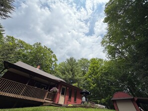 Ein rotes Gebäude mit Veranda, umgeben von Bäumen.