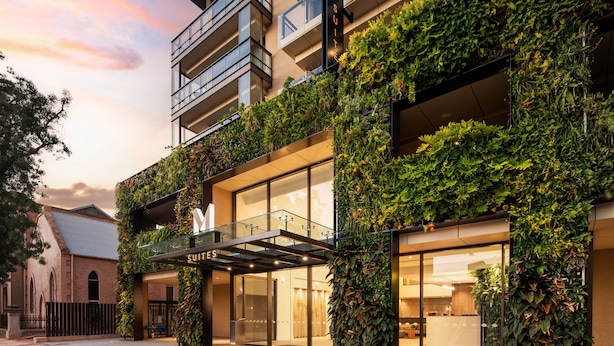A hotel with a modern facade, large glass windows, and a balcony with greenery. - Majestic M Suites (North Adelaide)