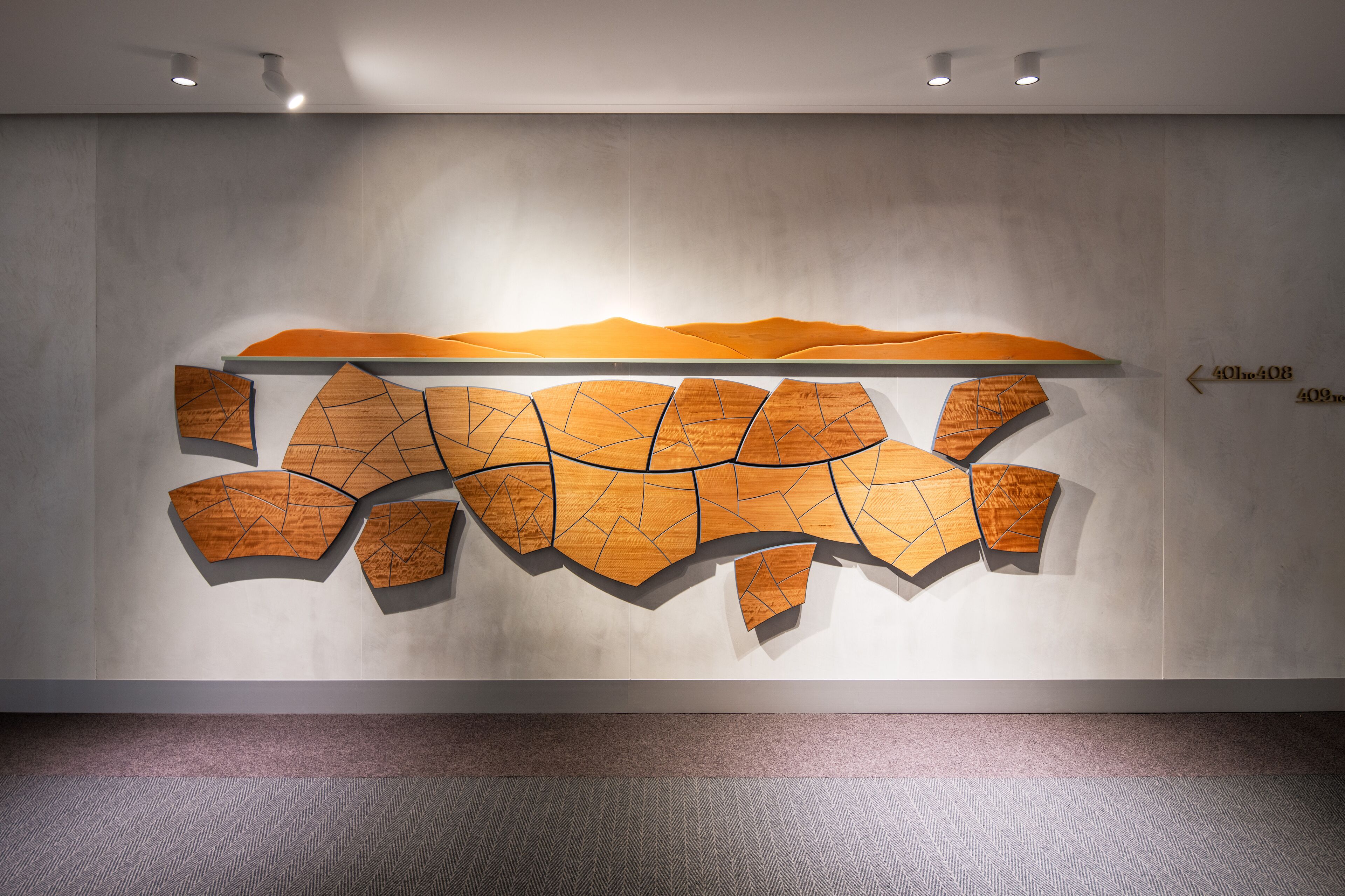 Un interior moderno con una gran obra de arte abstracta de madera en la pared.