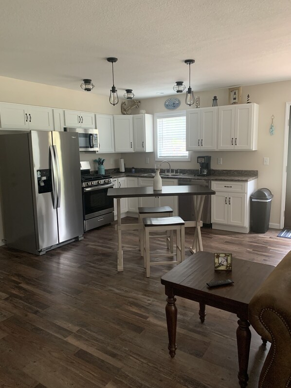 Enjoy casual dining at the kitchen's dining table and stools, equipped with a sink and coffee maker.