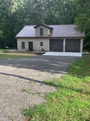 Guests can enjoy a front porch with a potted plant and a small table.