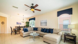 A living room with a sofa, coffee table, and a ceiling fan. - Ref 432. Stunning Villa at Bella Vida Resort near Disney. (Kissimmee)