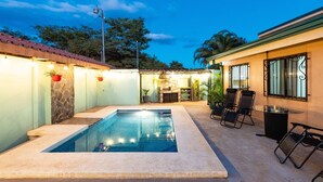 A swimming pool with a stone border, outdoor seating, and a stone fireplace. - In the middle of the best beaches, private house with pool. (Tamarindo)