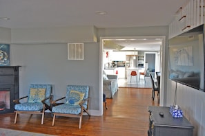 Relax in this inviting living area with a fireplace, dining table, and comfortable armchairs.