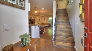 Una escalera conduce a una sala de estar, con una cocina al fondo.