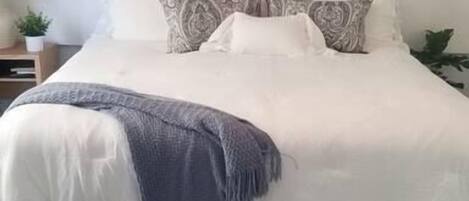 Ein Schlafzimmer mit einem Bett, einem Bild an der Wand und Holzboden.