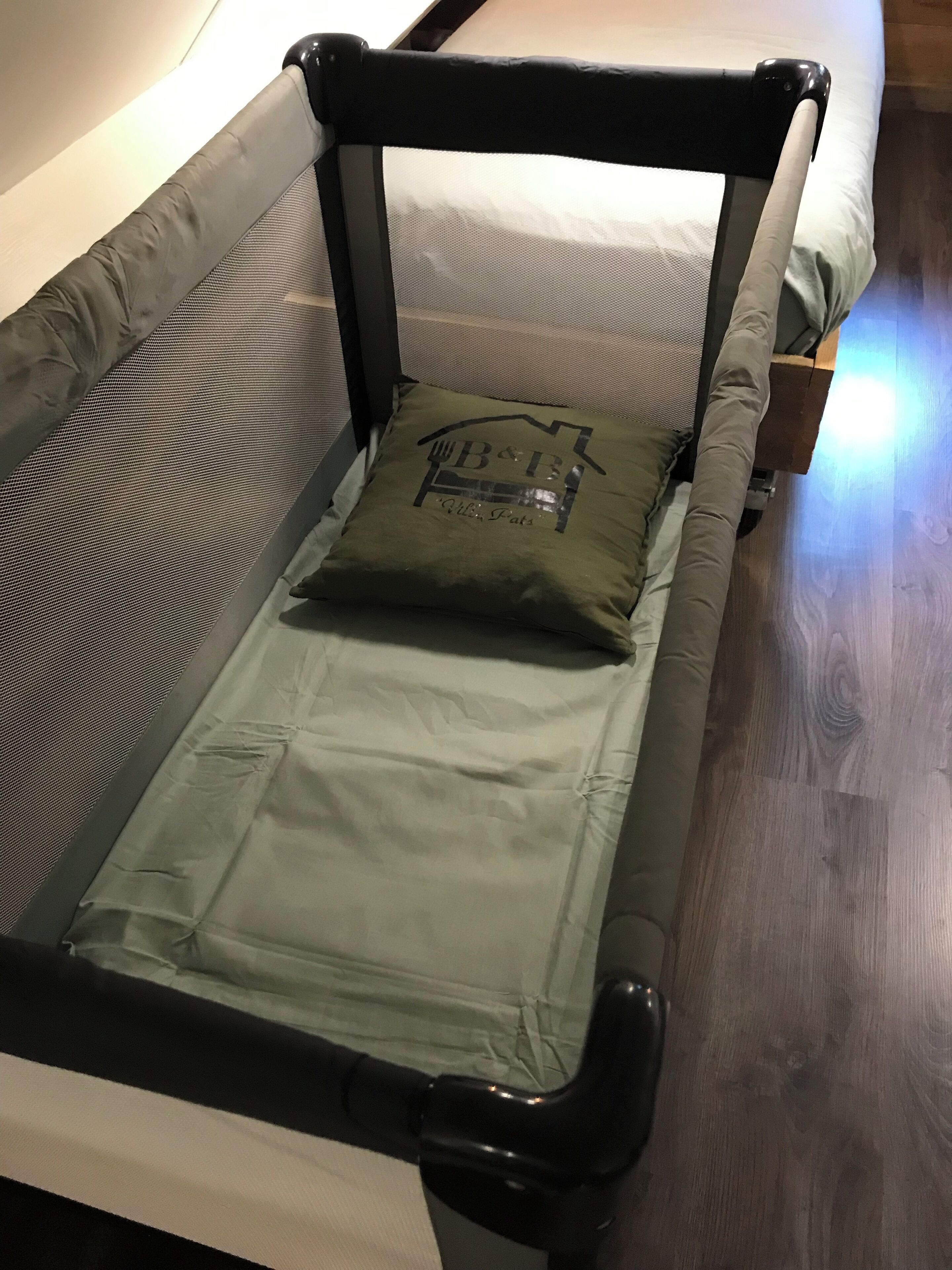 Un petit lit avec une tête de lit, un oreiller et un matelas.