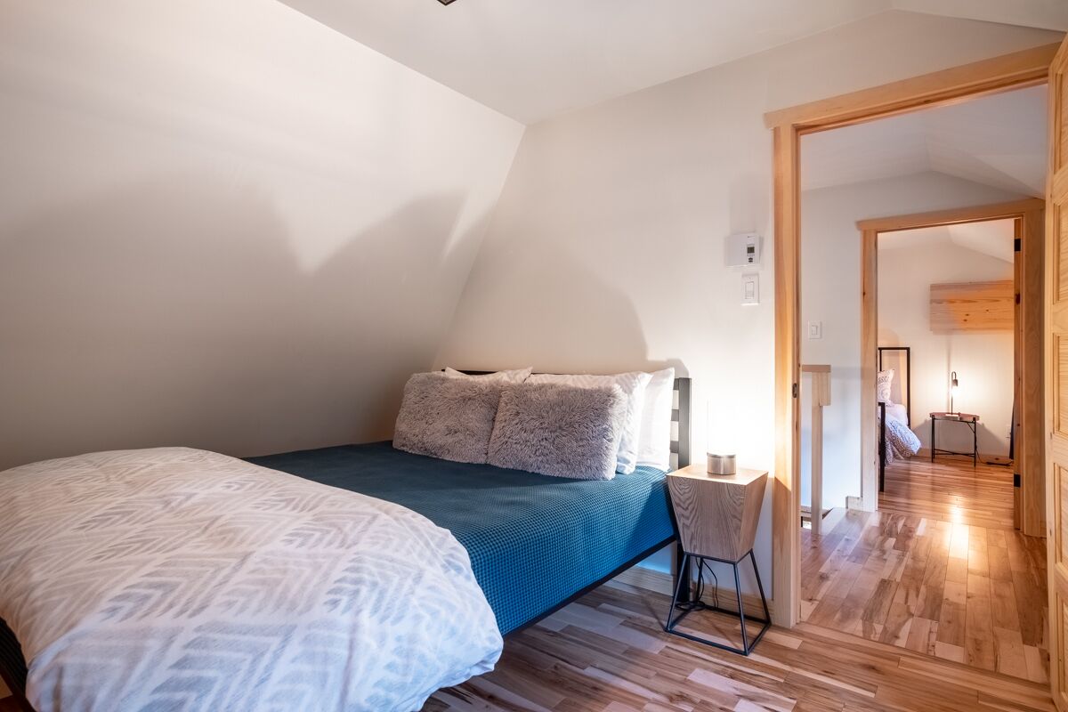 Een slaapkamer met een bed, een bureau en een stoel.
