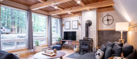 A cozy living room with a fireplace, a sofa, a coffee table, and a TV.