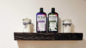 To hylder med glasbeholdere, der indeholder vatpinde og produkter fra Dr. Teal's skummende badesalt.
