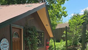 A wooden building with a door, a welcome sign, and a garden with yellow flowers. - ADK Rustic Private Chalet Viewing Two Ponds / Forest 5.3 miles To Gore Mountain (North Creek)