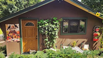 A wooden cabin with a door, windows, and a welcome sign.