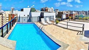 A rooftop pool with clear blue water, surrounded by a tiled deck and a metal railing. - Vacanze - Monteverdi (Maceió)